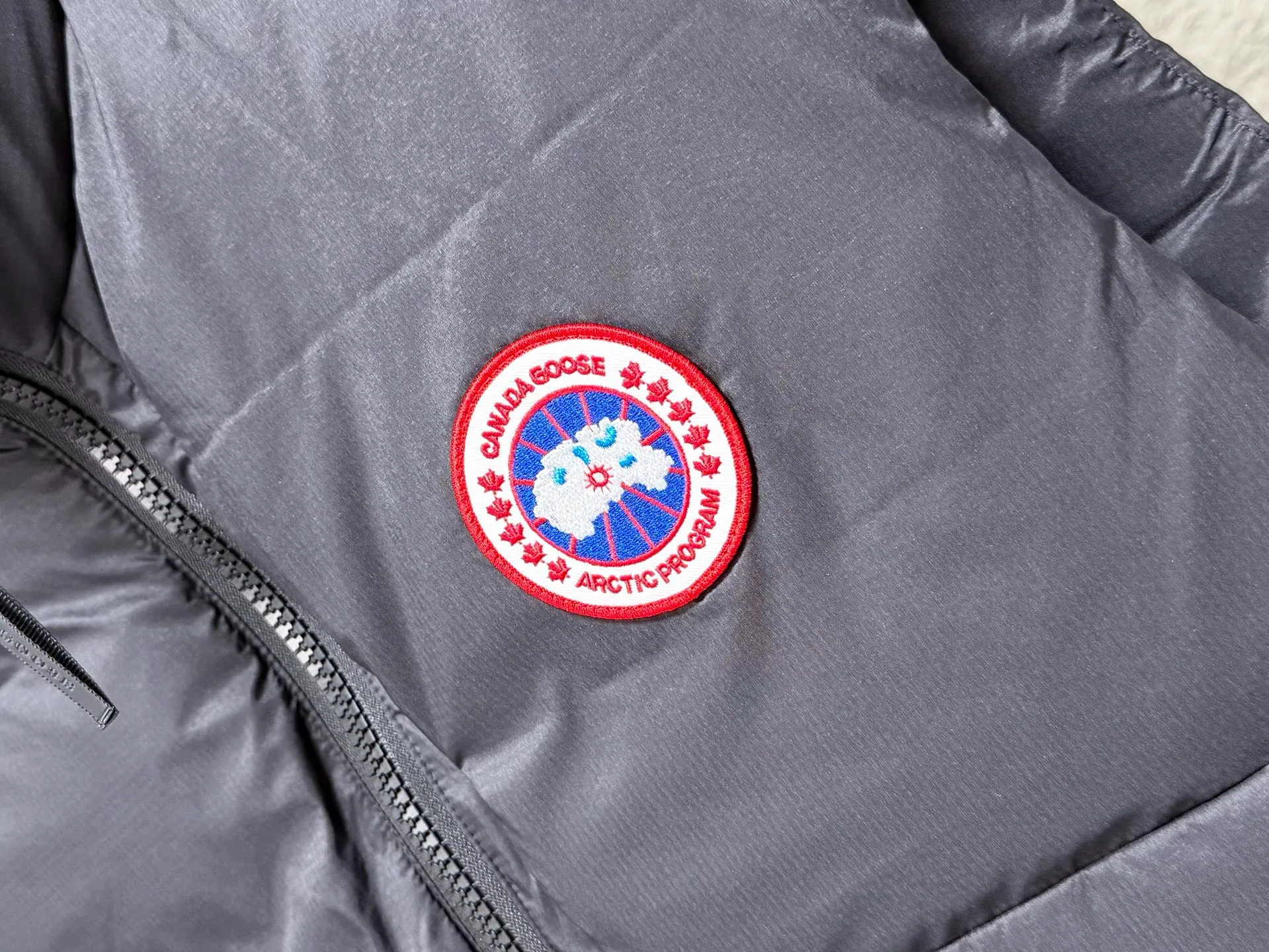 (High-quality) Canada Goose/Big Goose stand-collar lightweight down vest ●Selected tear-proof textured fabric, fine plaid texture, wind-resistant and durable, taking into account both light weight and toughness. ●Horizontal quilting segmented down lock technology, the down is evenly filled, not easy to run away, fluffy and not bloated. ●Classic red and black round emblem embroidery, the brand logo is exquisite and three-dimensional, low-key and high-end. ●High stand-up collar and windproof design, YKK zippers are smooth and durable, and the drawstring at the hem can be tightened freely to lock in warmth. ●Practical pockets on both sides make it easy to store small items; the stowable and portable design does not take up space when traveling. ●The cut is loose and neat, not flattering to your body shape. It can be worn alone in spring and autumn or layered with a coat in winter. It is suitable for urban commuting and outdoor travel. COLOUR:Black red label SIZE: S M L XL XXL